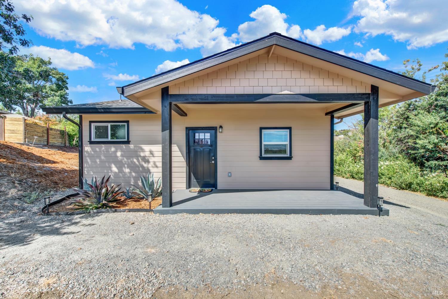 The newly built accessory dwelling unit with a covered front porch and exposed beam posts